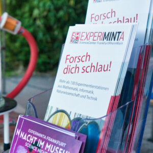 Flyer mit der Überschrift 'Forsch dich schlau!' und Informationen zu über 130 Experimentierstationen aus Mathematik, Informatik, Naturwissenschaft und Technik.